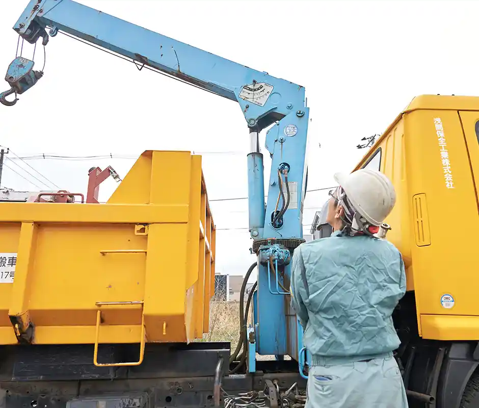 クレーン車の前で作業するスタッフ
